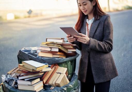 Firefly A pile of books sits in a garbage can. Next to the garbage can, a person is standing and rea